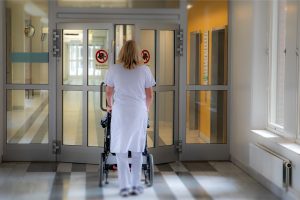 Sjuksköterska som går i en vårdkorridor